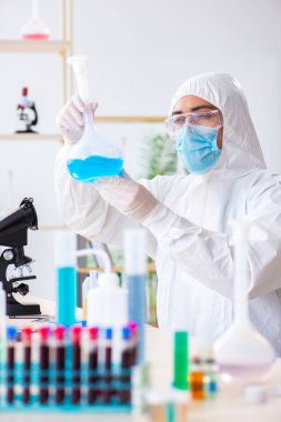 Laboratuvarda kimyasallar üzerinde çalışan genç bir kimyager.