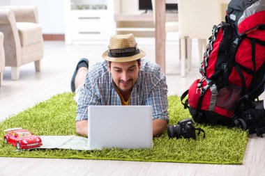 Genç adam internetten seyahat etmeyi planlıyor.