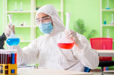 Laboratuvarda yeni bir deney üzerinde çalışan kimyager.