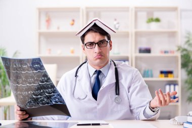 Genç doktor klinikteki röntgen görüntülerine bakıyor.