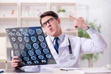 Genç doktor klinikteki röntgen görüntülerine bakıyor.