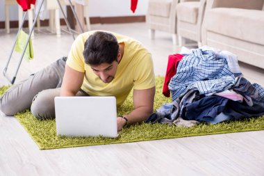 Yakışıklı koca evde çamaşır yıkıyor.