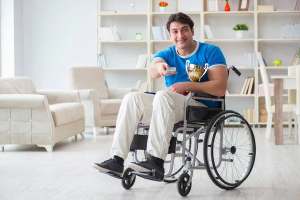 Zdravotně postižený muž sleduje sport v televizi — Stock fotografie