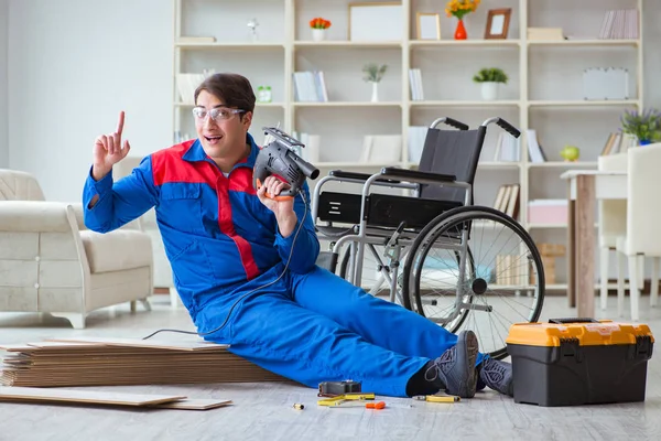 Homem com deficiência que estabelece piso laminado no escritório — Fotografia de Stock