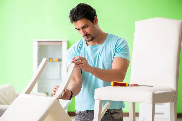 Мужчина ремонтирует мебель дома — стоковое фото