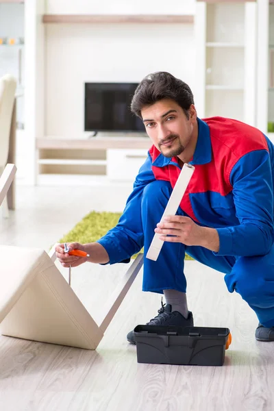 Reparação de empreiteiro reparando cadeira quebrada em casa — Fotografia de Stock