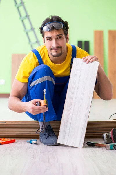 Empreiteiro profissional que coloca piso em casa — Fotografia de Stock