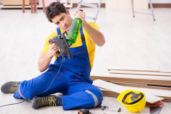 Floor repairman drinking alcohol during break — Stock Photo, Image