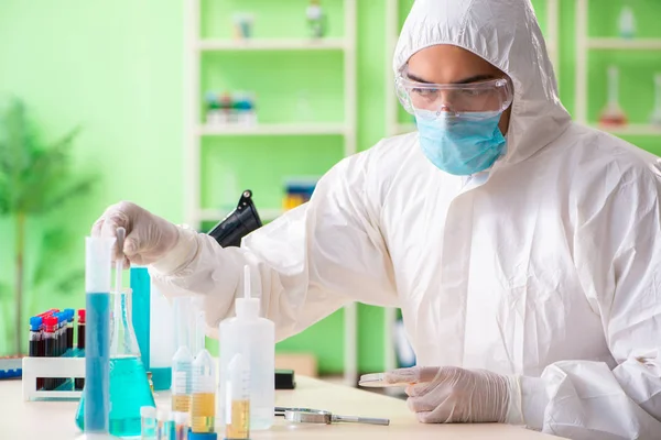 Laboratuvarda yeni bir deney üzerinde çalışan kimyager.