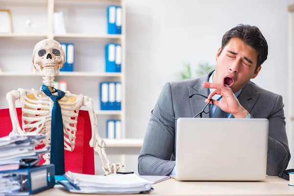 İskeletle çalışan bir iş adamı.