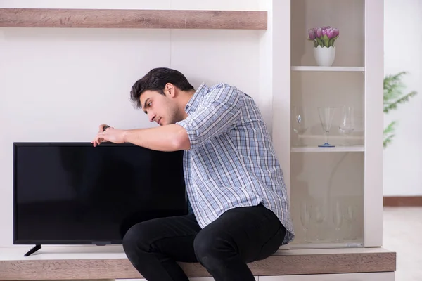 Man repairing broken tv at home