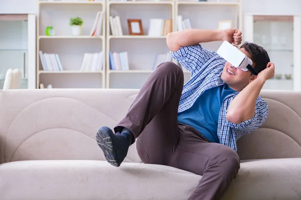 Evde sanal gerçeklik gözlüklü bir adam oynuyor.