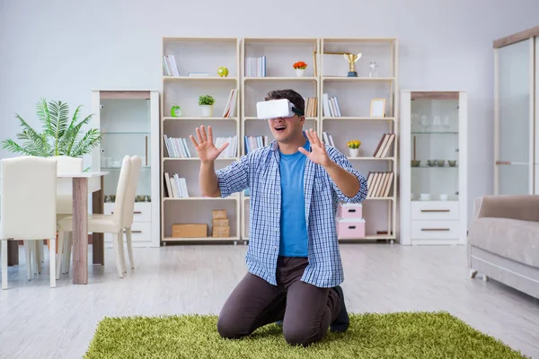 Evde sanal gerçeklik gözlüklü bir adam oynuyor.