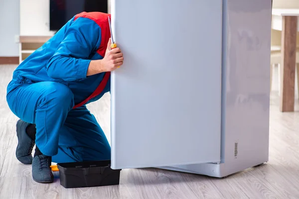 Professional contractor repairing broken fridge — Stock Photo, Image