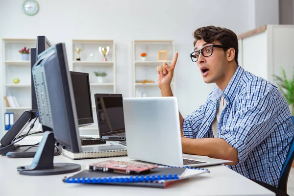 Birçok ekranın önünde oturan bir iş adamı