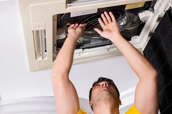 Repairman repairing ceiling air conditioning unit — Stock Photo, Image