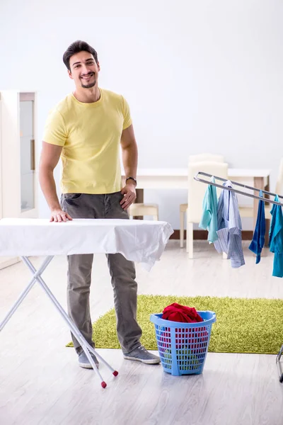 Bonito homem marido fazendo roupas de engomar em casa — Fotografia de Stock