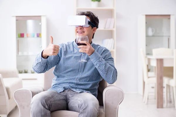 Genç adam evde şarap içiyor.