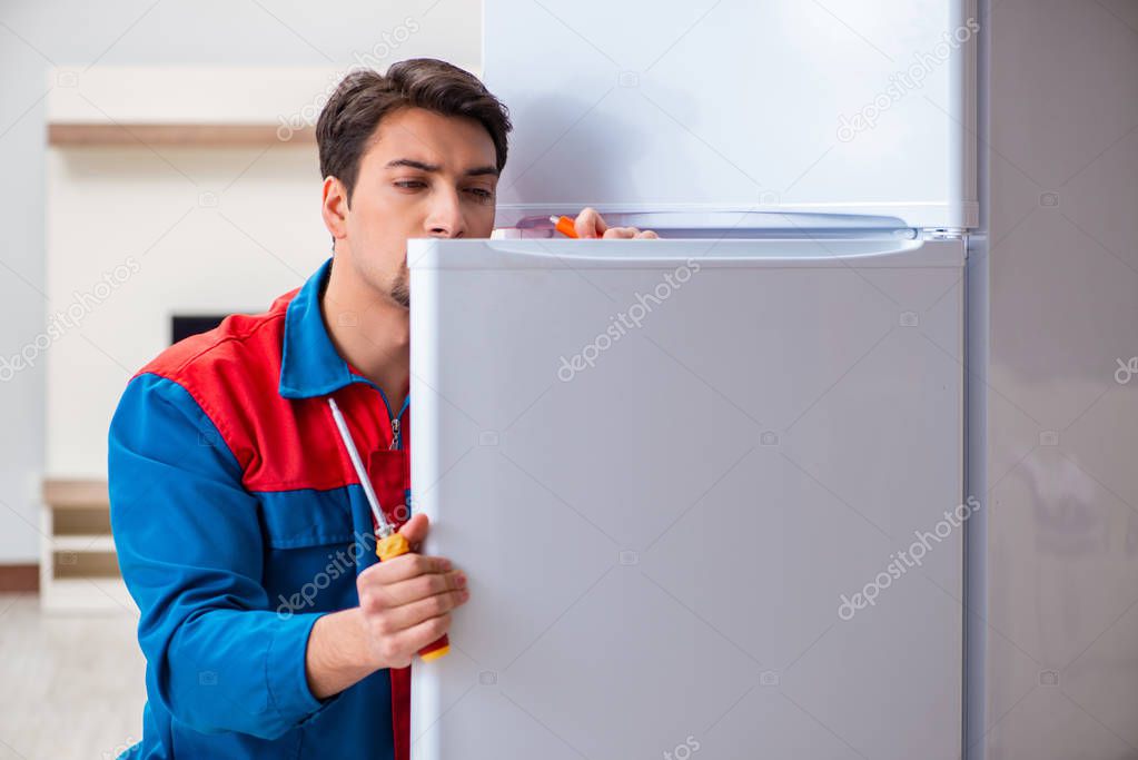 Professional contractor repairing broken fridge