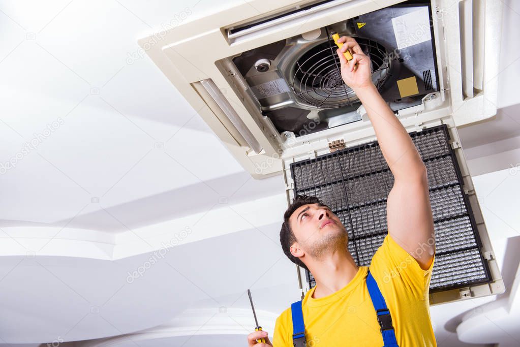 Repairman repairing ceiling air conditioning unit