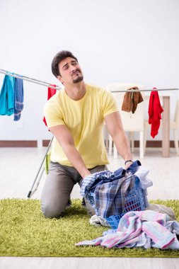 Yakışıklı koca evde çamaşır yıkıyor.