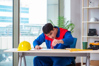 Foreman inşaat planına bakıyor.