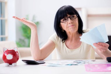 Faturalarını ödemeye çalışan olgun bir kadın.