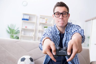 Genç adam evde bilgisayar oyunu oynuyor.