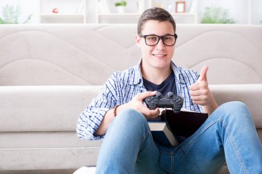 Çalışmayı ve oyun oynamayı dengelemeye çalışan genç öğrenci