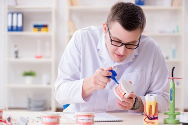 Tıp laboratuarına diş implantı yerleştiren dişçi.