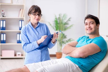 Doktor çekiçle sinir reflekslerini kontrol ediyor