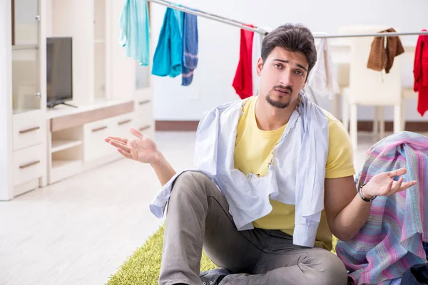 Yakışıklı koca evde çamaşır yıkıyor.