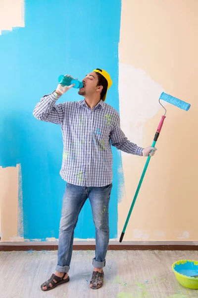 Pintor hombre pintando la pared en casa — Foto de Stock