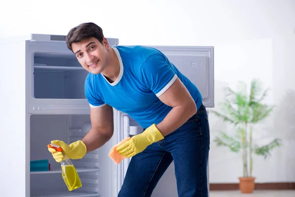 Mann putzt Kühlschrank im Hygienekonzept — Stockfoto