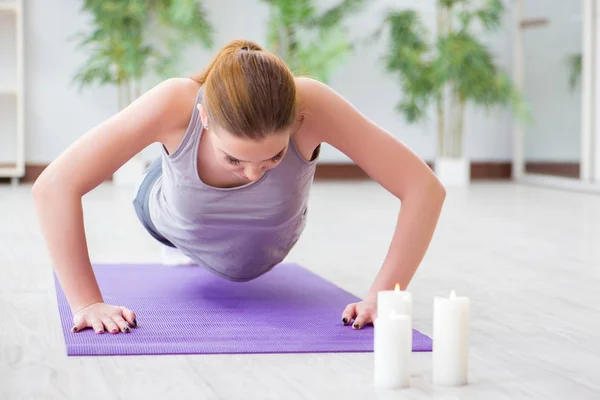 Mujer joven haciendo ejercicio en el pabellón deportivo en concepto saludable — Foto de Stock