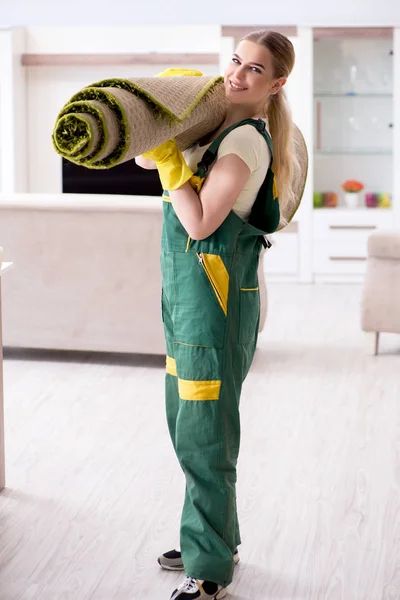 Professional female cleaner cleaning carpet