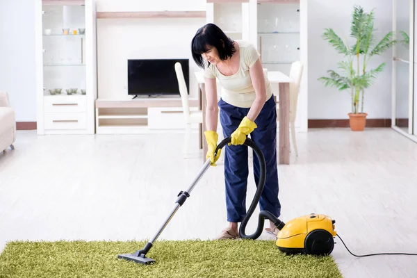 Yaşlı kadın elektrik süpürgesinden yorgun düştü.