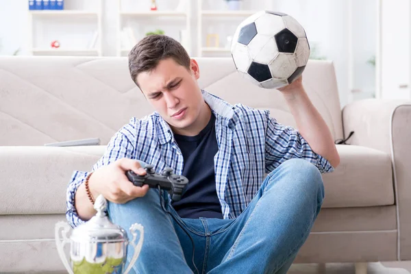 Genç adam evde bilgisayar oyunu oynuyor.