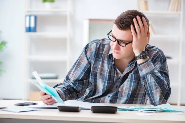 Jongeman gefrustreerd door zijn huis en belastingen rekeningen — Stockfoto