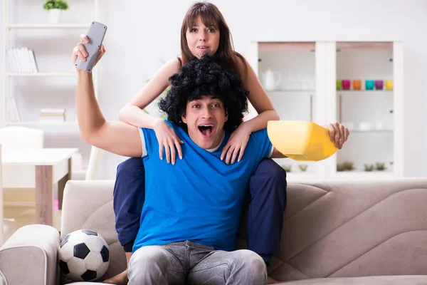 Joven hombre viendo fútbol con su esposa en casa —  Fotos de Stock