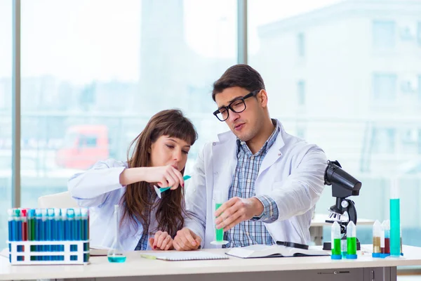 Dois químicos que trabalham em laboratório experimentando — Fotografia de Stock