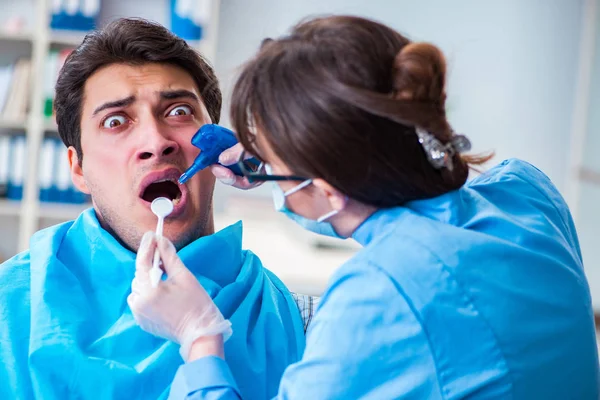 Patiënt bang voor tandarts tijdens doktersbezoek — Stockfoto