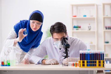 Laboratuvarda çalışan iki kimyager.