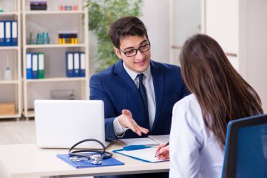 İş adamı doktorla sağlık sorunlarını tartışıyor