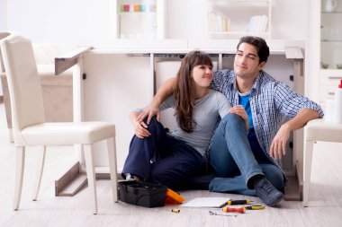 Erkek ve kadın evde mobilya montajı yapıyor.