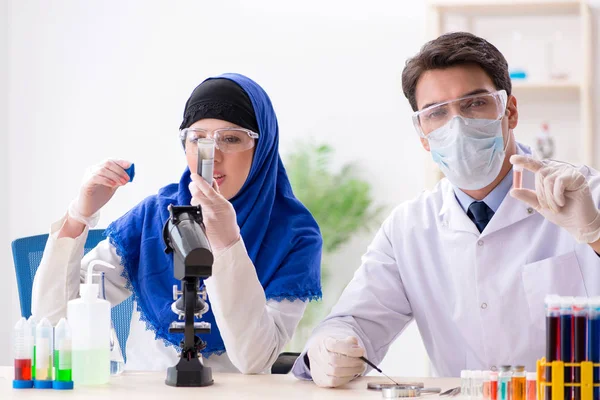 Laboratuvarda çalışan iki kimyager.