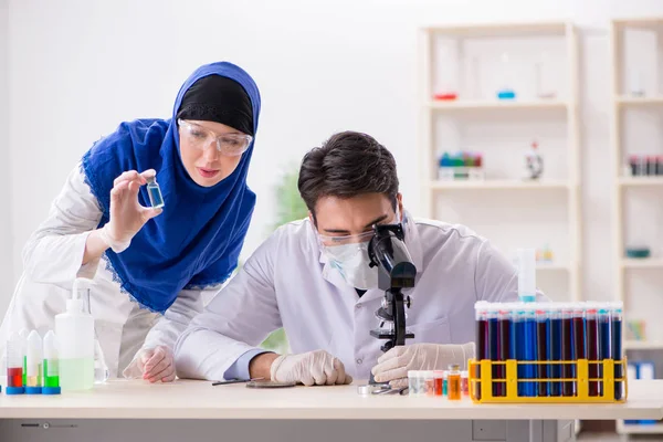 Laboratuvarda çalışan iki kimyager.