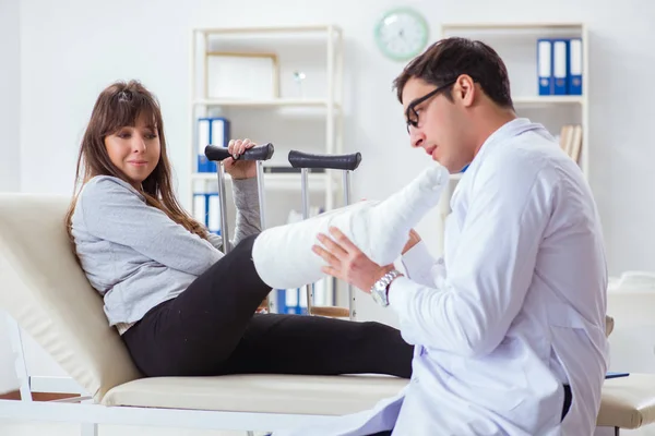 Doctor examining patient with broken leg — Stock Photo, Image