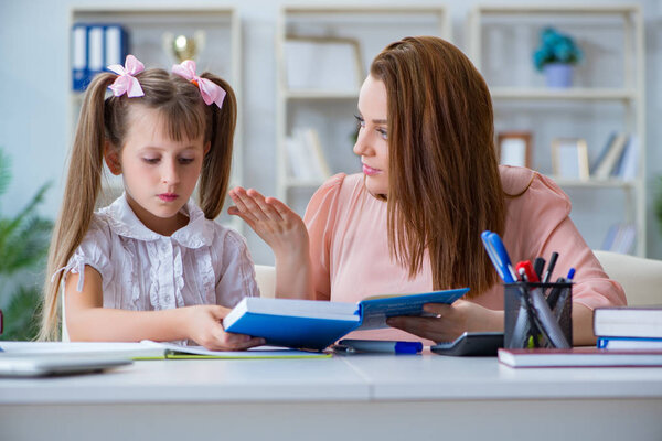 Mother helping her daughter to do homework