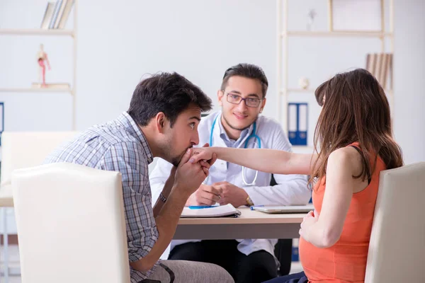 Pregnant woman with her husband visiting the doctor in clinic — Stock Photo, Image
